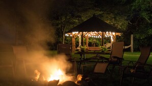 A gazebo with string lights, a fire pit, and outdoor furniture. - Stevenson Inn & Spa (Essa)