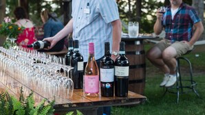 A wine tasting event with several wine bottles and glasses on a wooden table. - Stevenson Inn & Spa (Essa)