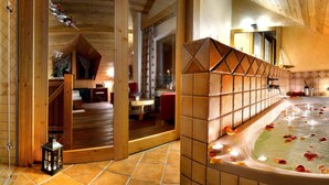 Un baño con una bañera grande, paredes de madera y piso de baldosas.