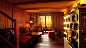 Una sala de estar acogedora con chimenea, muebles de madera y vistas al exterior.