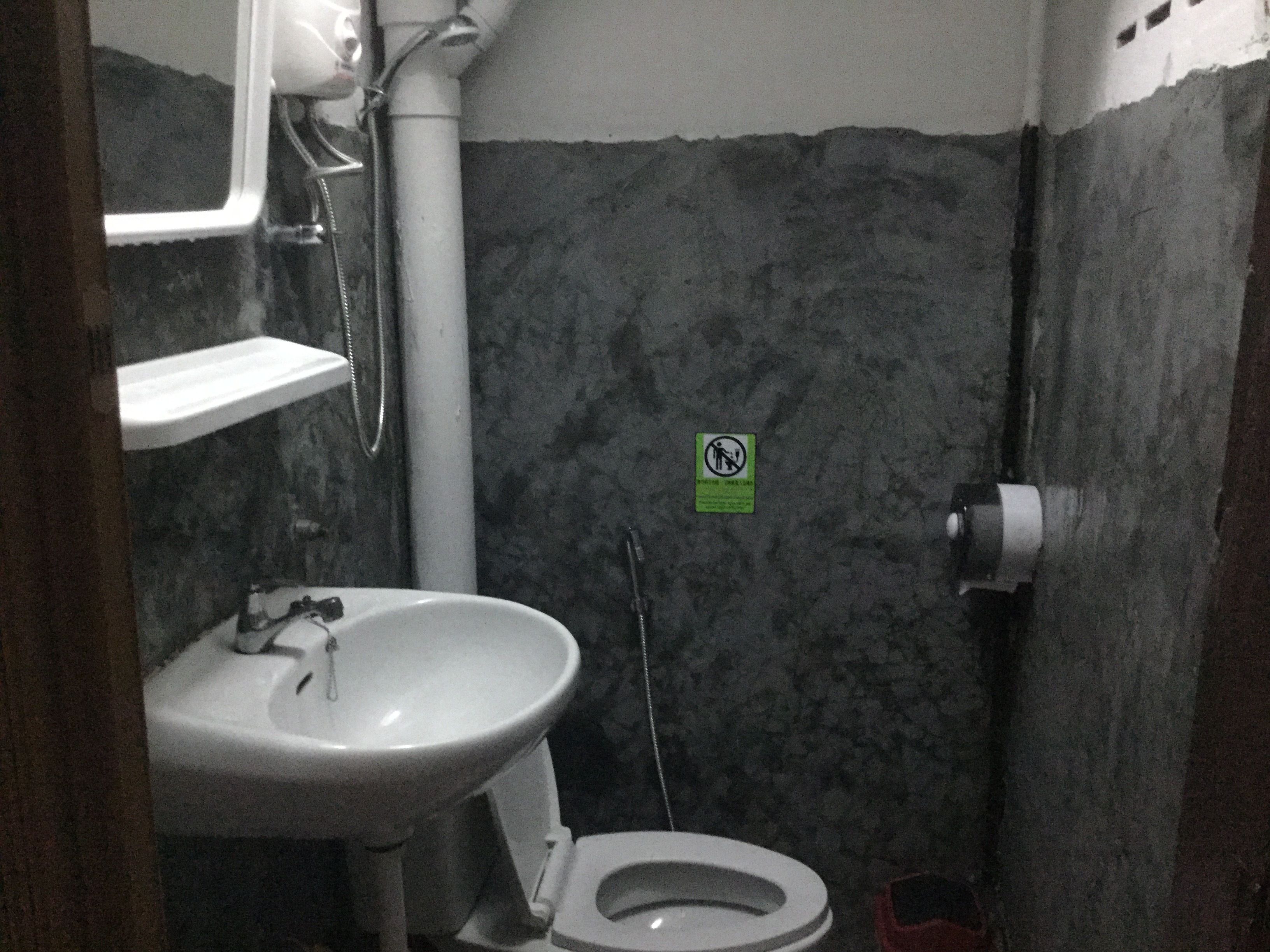 A small bathroom with a sink, toilet, and shower.