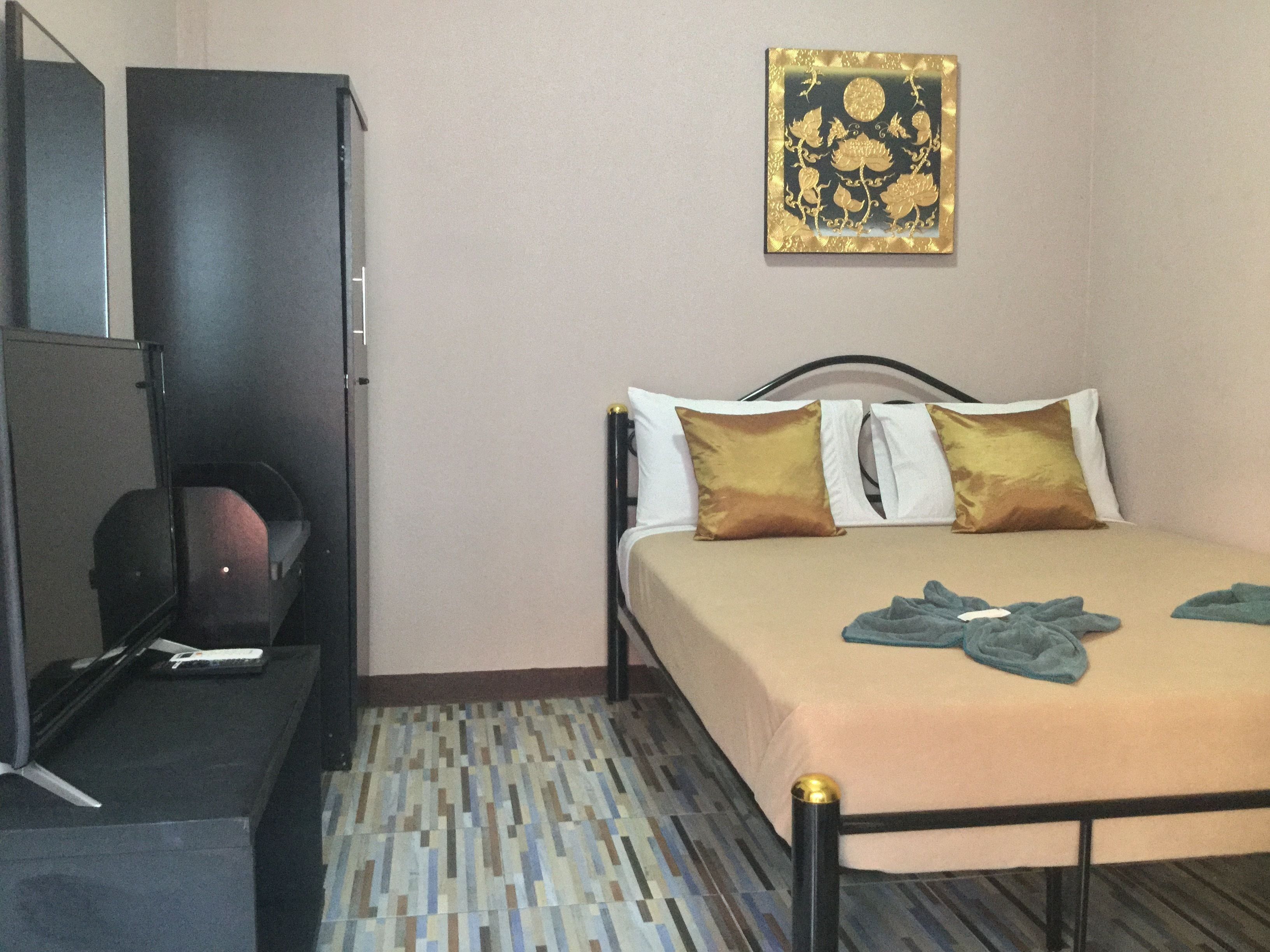 A bedroom with a bed, a wardrobe, and a small table.