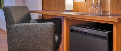 A modern kitchen with a built-in dishwasher, a wooden countertop, and a chair.