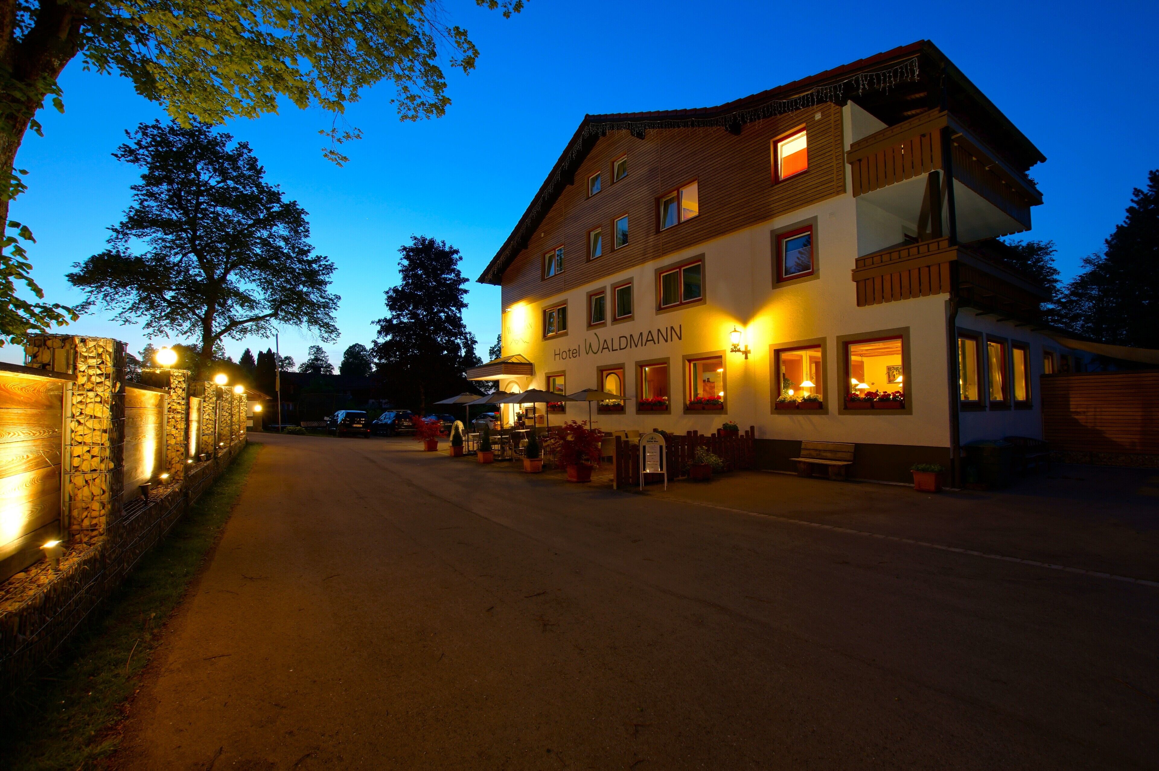 Un hotel de dos pisos con un letrero que dice "Hotel Waldmann".