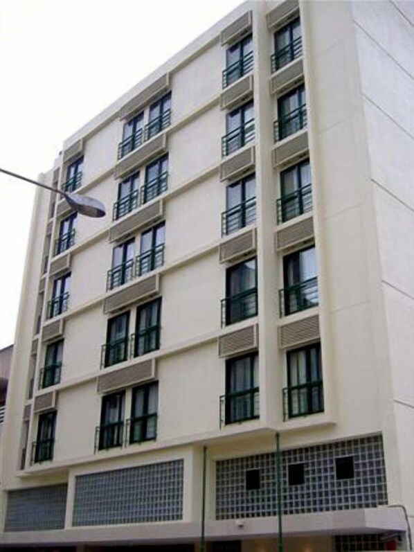 A multi-story building with a flat facade, evenly spaced windows, and a grid-like pattern on the lower level.