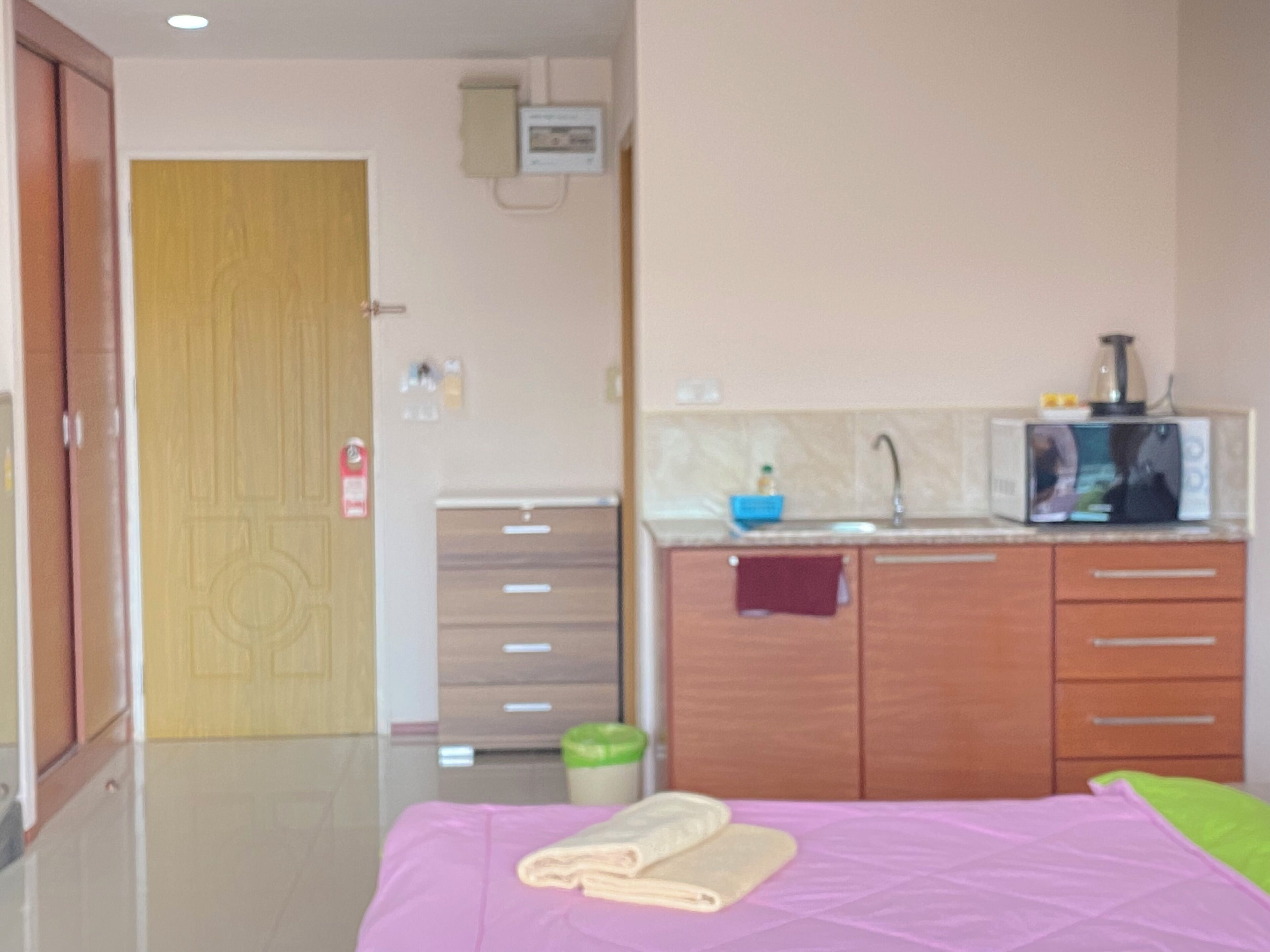 Un dormitorio con cama, un baño con lavamanos y un armario de madera.