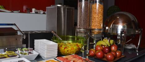 A buffet setup with various food items and serving utensils.