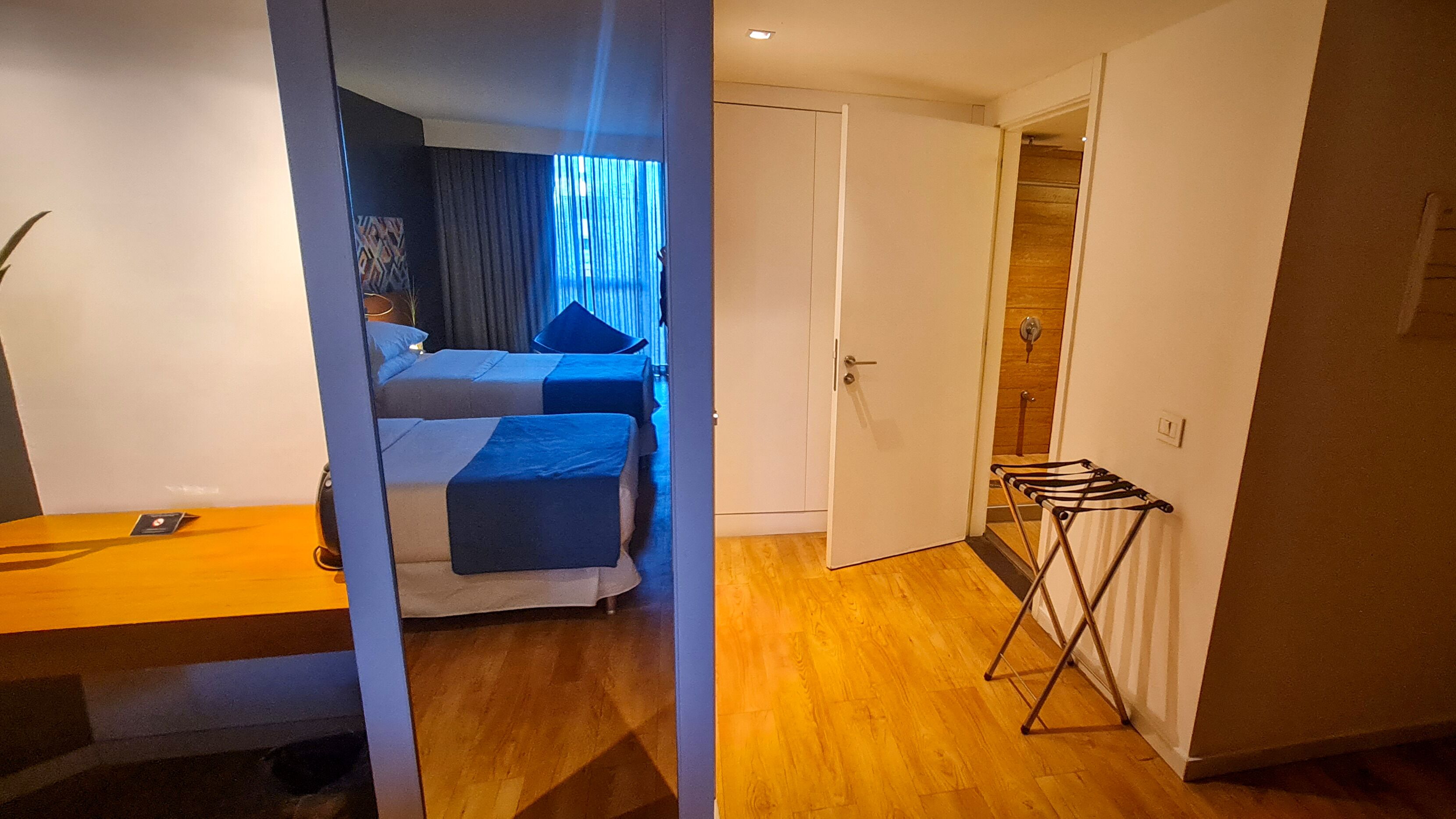 A hotel room with a bed, a desk, and a wardrobe.