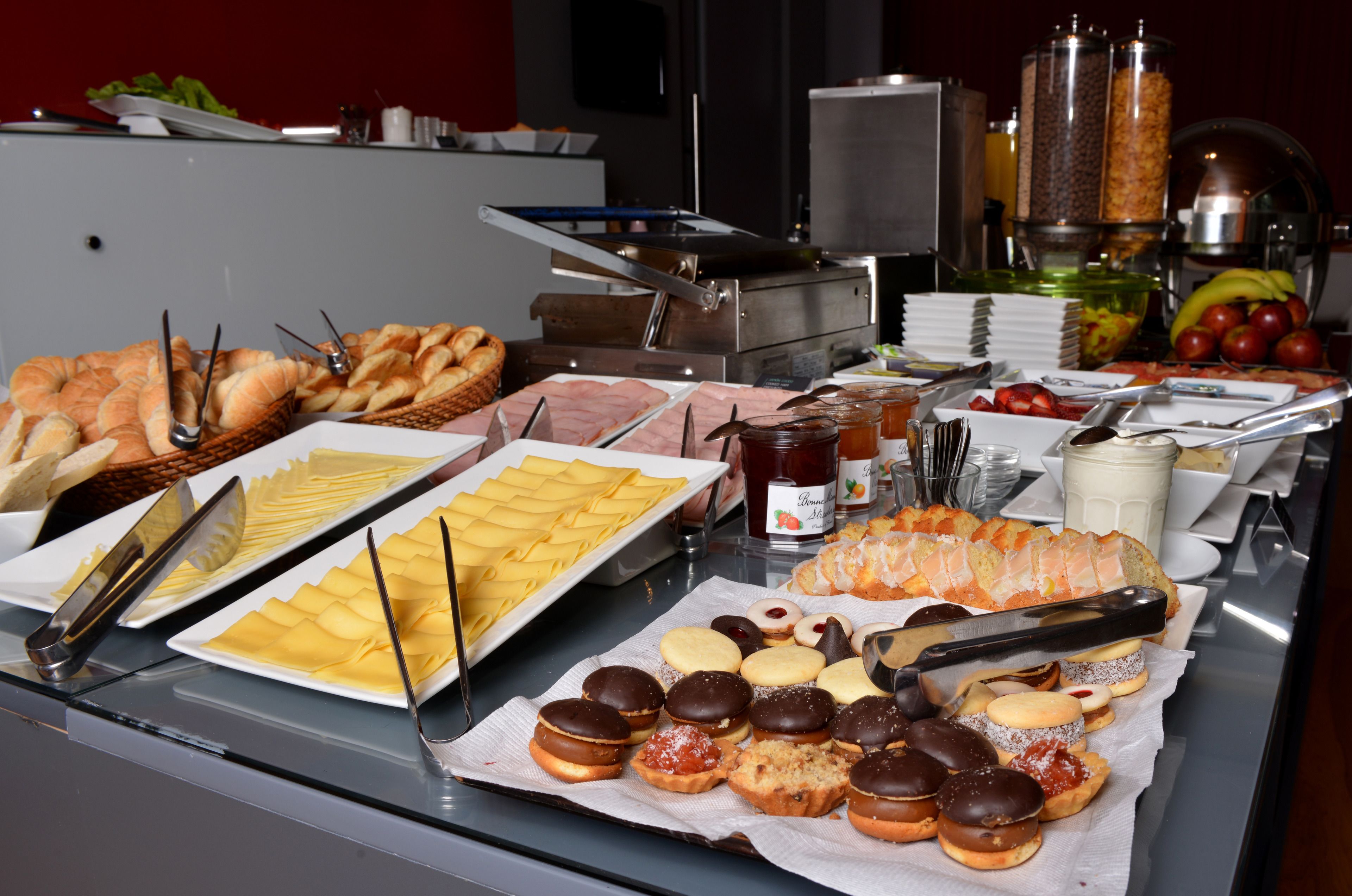 Un bufé con diversos alimentos, incluyendo pasteles, carnes y frutas.