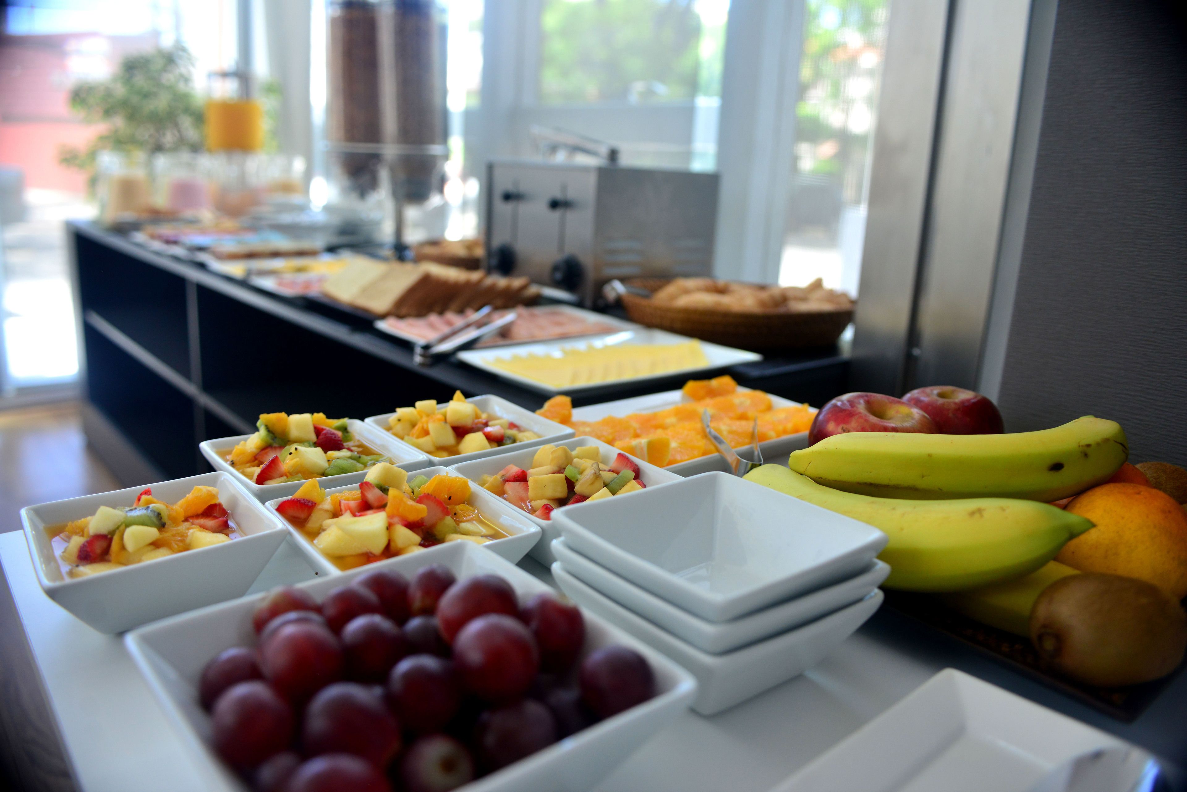 Un bufé con frutas y platos variados.