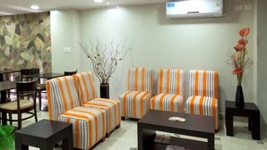 A modern living room with striped sofas, a coffee table, and a dining area with chairs and a table. - Munay Ledesma (Libertador General San Martin)