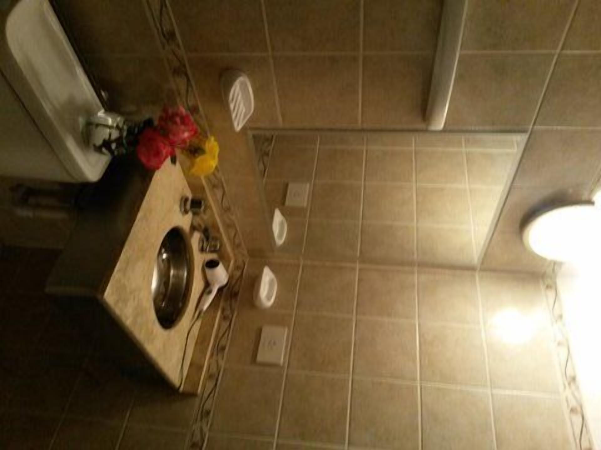 A bathroom with a sink, mirror, and a toilet.