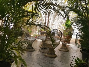 Un espace patio aménagé avec des meubles en osier et des plantes en pot.