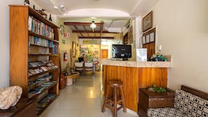 Una habitación acogedora y bien iluminada con una estantería de madera, una pequeña zona de bar y un espacio de estar confortable.