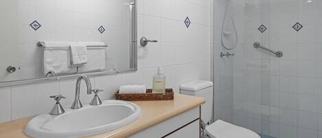 A modern bathroom with a sink, mirror, and toilet.