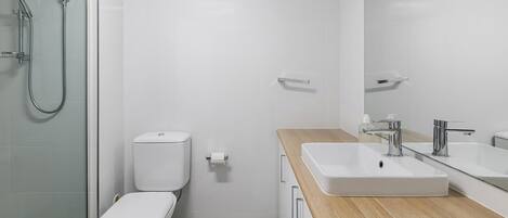 A modern bathroom with a toilet, bidet, and shower.