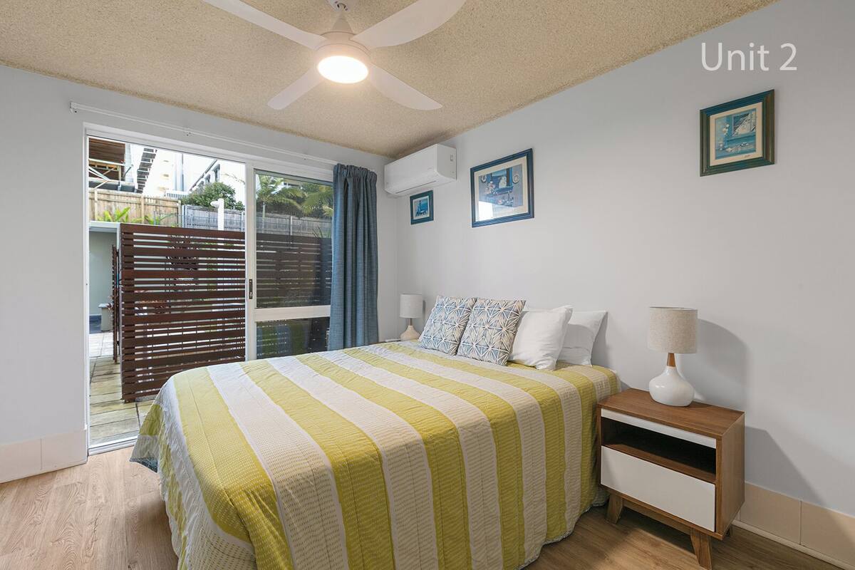 A bedroom with a bed, bedside tables, and a ceiling fan.