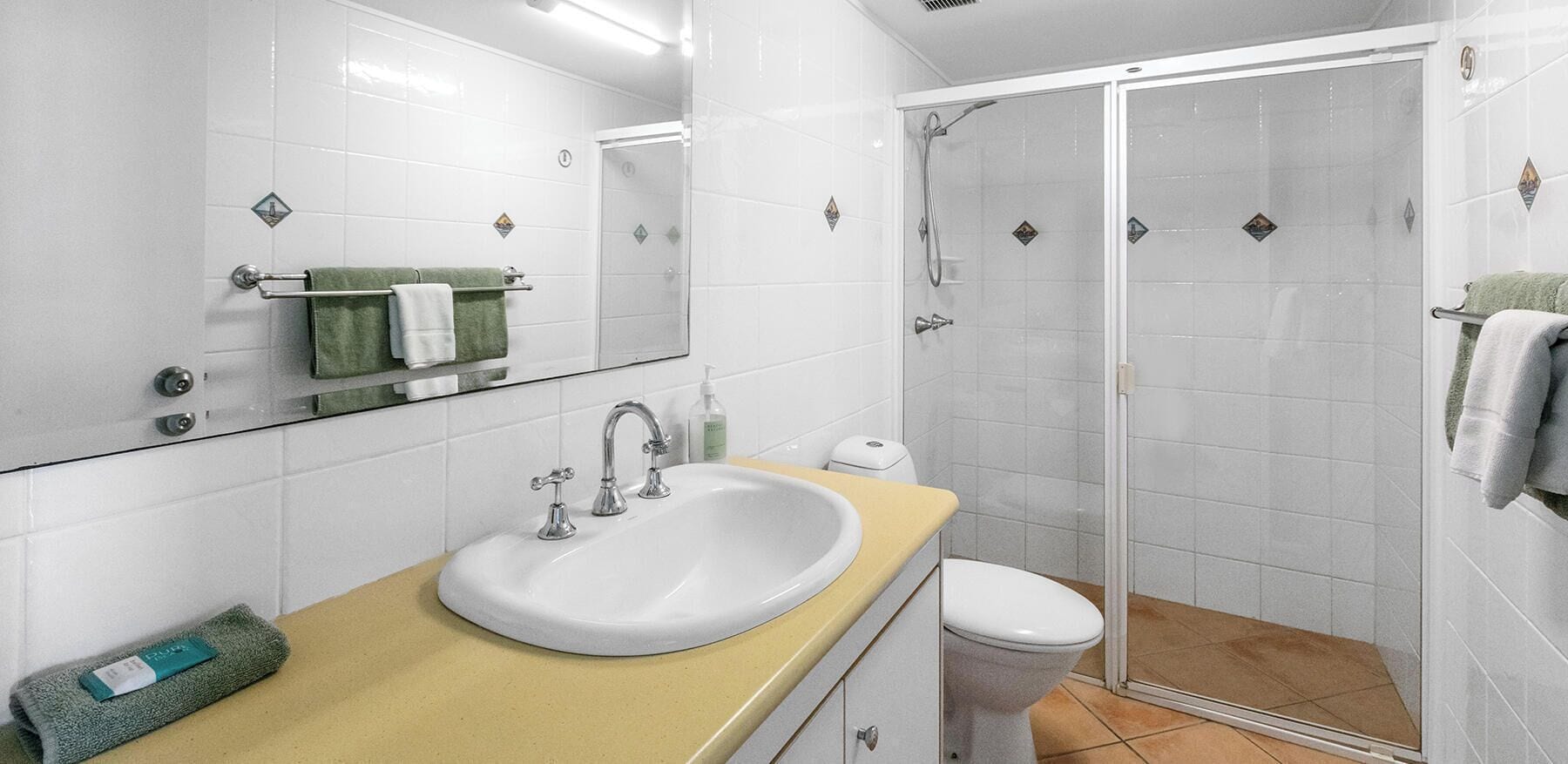 A modern bathroom with a sink, toilet, and walk-in shower.