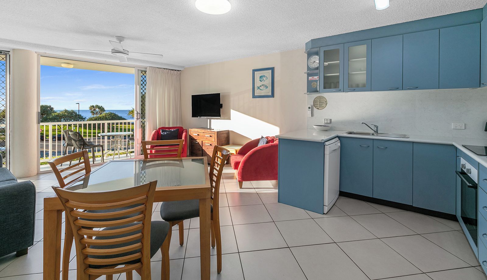 Un appartement moderne doté d’un coin repas, d’une cuisine et d’un balcon offrant une vue agréable.