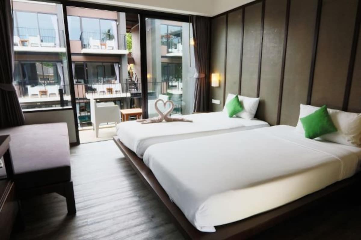 Una habitación de hotel con una cama grande, un escritorio y vistas al balcón exterior.