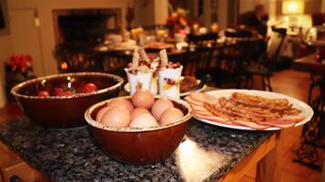 Un comptoir de cuisine avec un bol d’œufs, une assiette de bacon et un dessert.