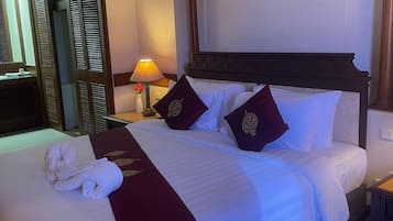 Ein Hotelzimmer mit einem großen Bett, einem Nachttisch, einer Lampe und einem Kleiderschrank.