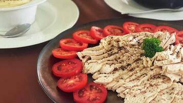 Une table de buffet avec des panneaux indiquant les différents plats, notamment des « tranches de poulet » et un « coin sandwich ».