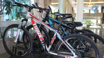 A row of bicycles parked indoors, likely in a lobby or public area of a building.