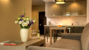 Un salon moderne comprenant un canapé, une table basse ornée d’un vase de fleurs et un coin repas avec une table et des chaises.
