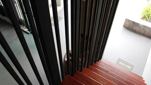 A wooden staircase with a 'WELCOME' sign at the bottom. - Siwa House (Pattaya)