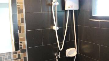 A bathroom with a white sink, a shower with a handheld showerhead, and a wall-mounted control panel.
