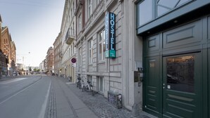 Un hostal con una puerta verde y un letrero que dice "HOSTEL".