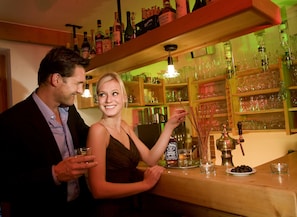 A bar area with shelves of liquor bottles and glasses.