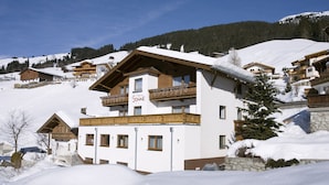 A hotel with a white facade, wooden balconies, and a sign reading "Sonne." - Hotel Sonne (Tux)