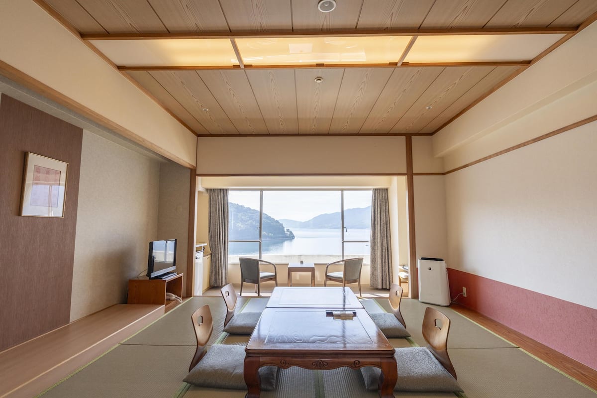 Een traditionele Japanse kamer met tatami vloeren, een lage houten tafel en stoelen.
