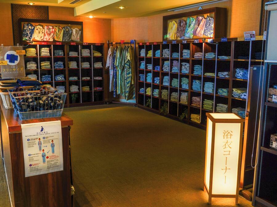 Una habitación ordenada con estantes llenos de ropa doblada y una exhibición de camisas perfectamente dobladas.