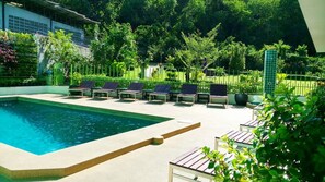 Piscina a l'aire lliure, para-sols i gandules