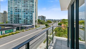 A modern building with a glass facade, a clear sky, and a road with vehicles. - The Kingsford, an Ascend Collection Hotel (Hamilton)