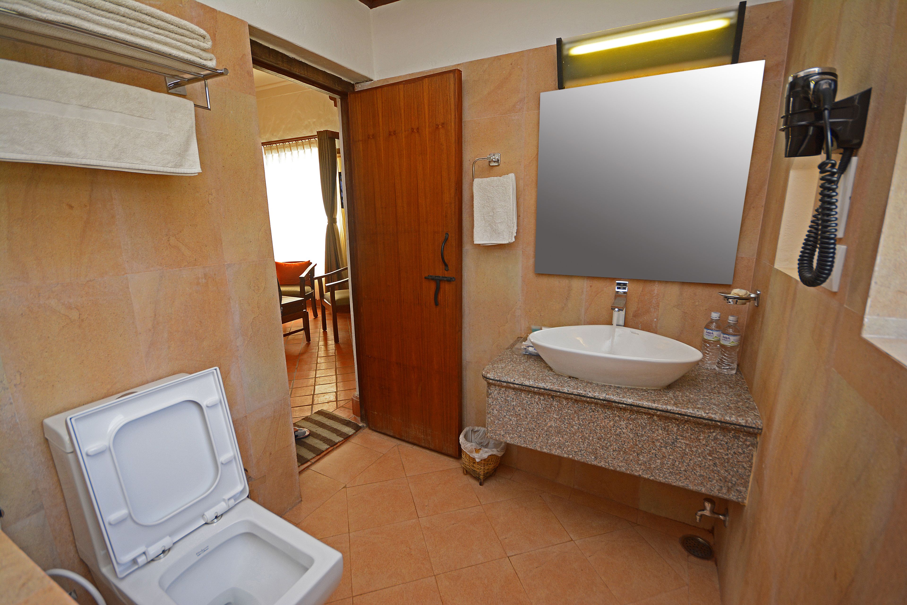 Een badkamer met toilet, wastafel en spiegel.