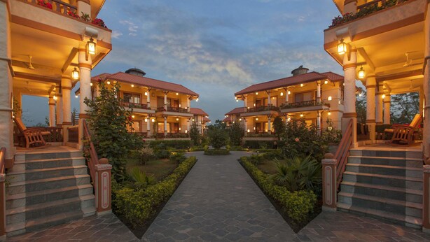 A hotel with two-story buildings, a central pathway, and surrounding greenery. - Green Park Chitwan (Sauraha)