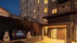 The exterior of the Central Hotel with a modern design, featuring a large signboard, a stone elephant sculpture, and a well-lit entrance. - Central Hotel Takeo Onsen (Takeo)