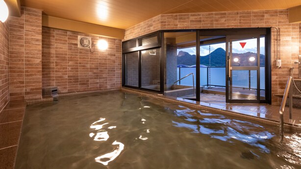 A hot tub area with tiled walls and a view of mountains. - Central Hotel Takeo Onsen (Takeo)