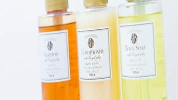 Tres botellas de productos para el cuidado corporal con etiquetas.