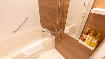 Ein Badezimmer mit Badewanne, Dusche und Ablage für Toilettenartikel.