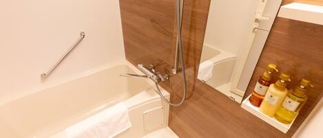 A bathroom with a bathtub, a shower, and a shelf with toiletries.