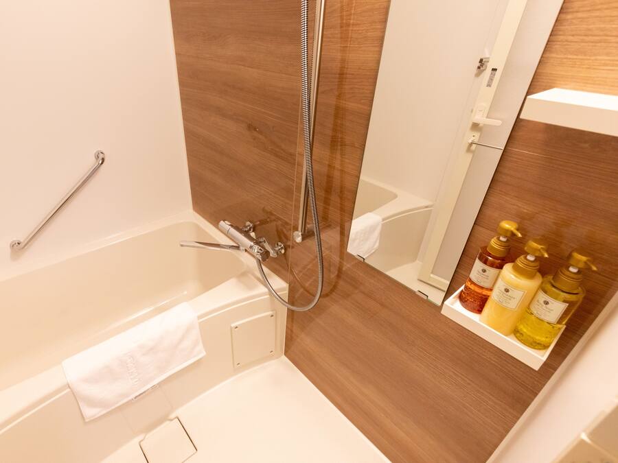 Ein Badezimmer mit Badewanne, Dusche und Ablage für Toilettenartikel.