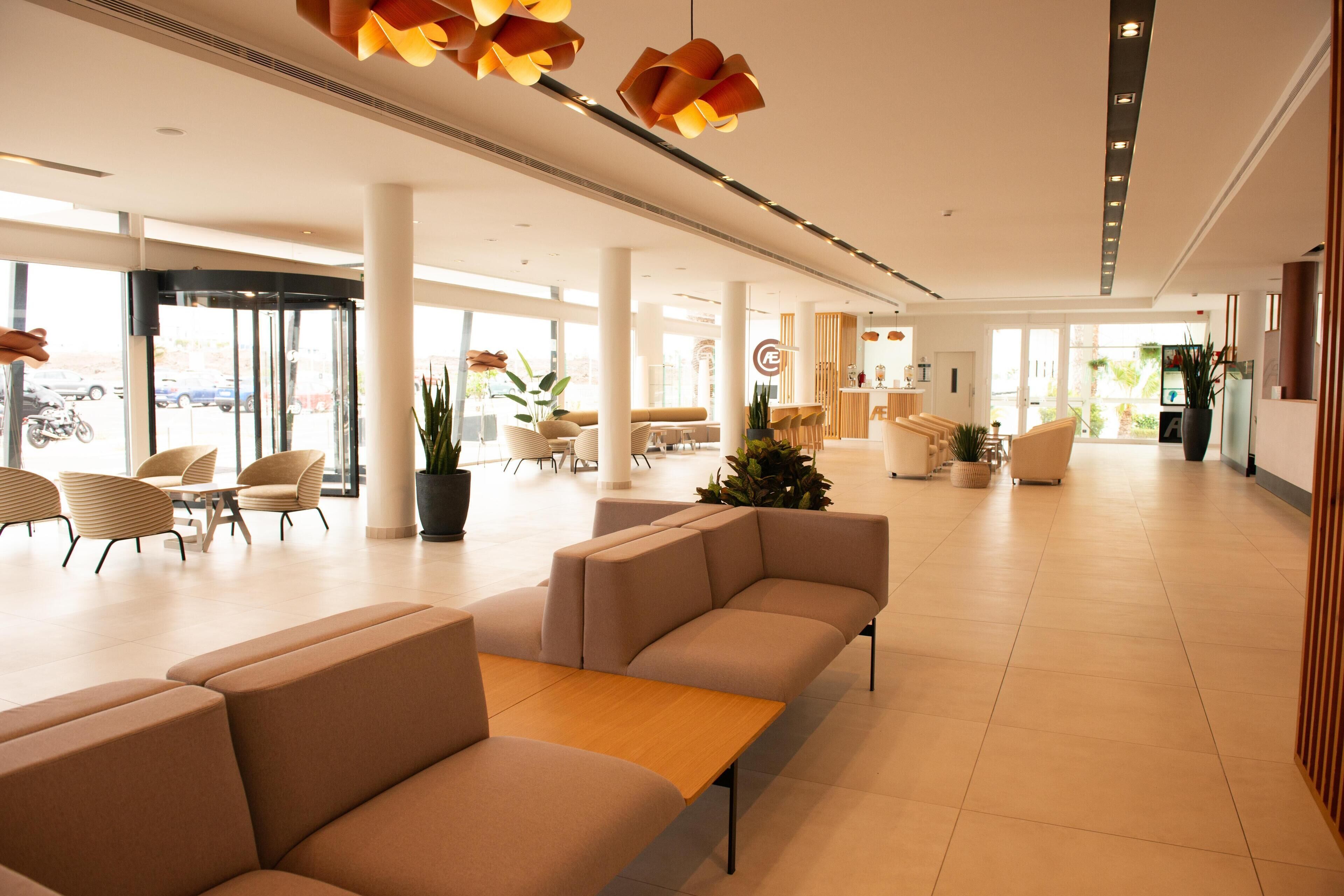 A spacious lobby with modern seating, a reception area, and large windows.