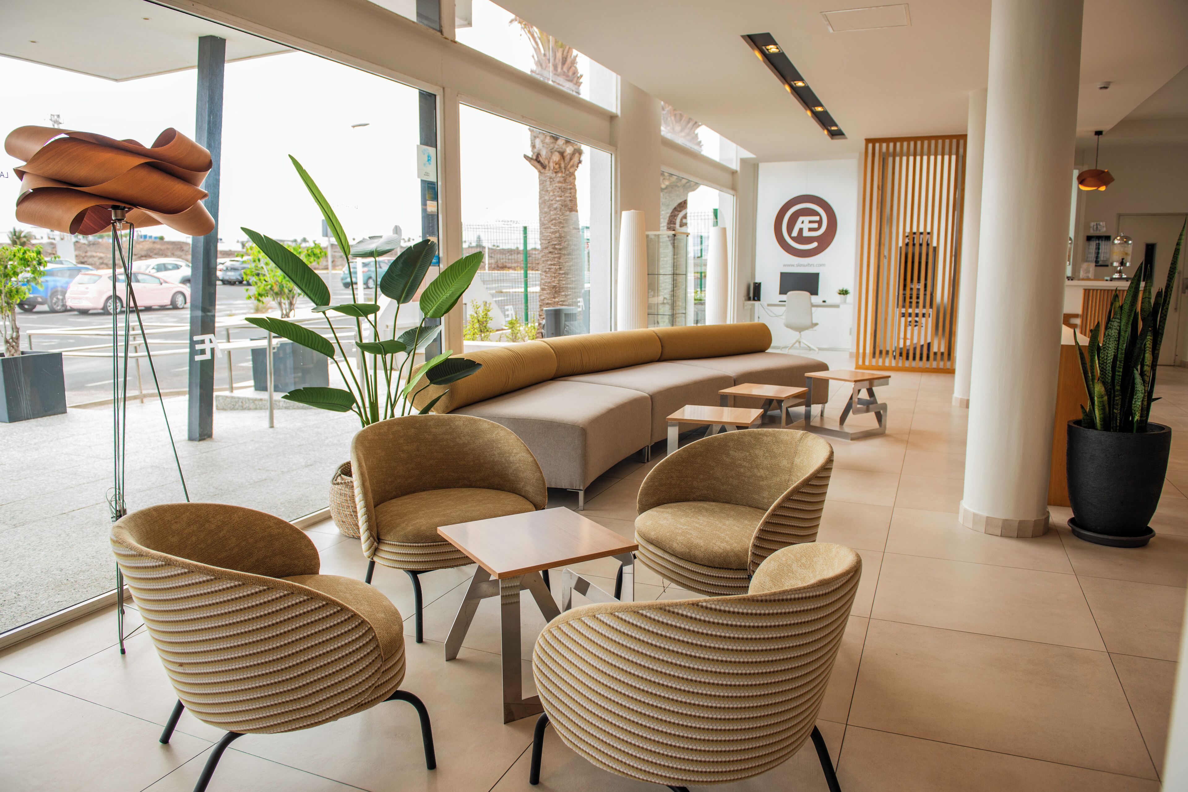 Een modern interieur met een zithoek, grote ramen en kamerplanten.