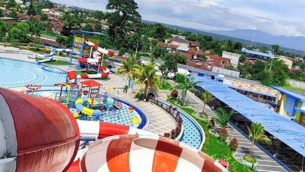 Un parc aquatique doté de toboggans et de piscines, entouré de bâtiments résidentiels et de verdure.