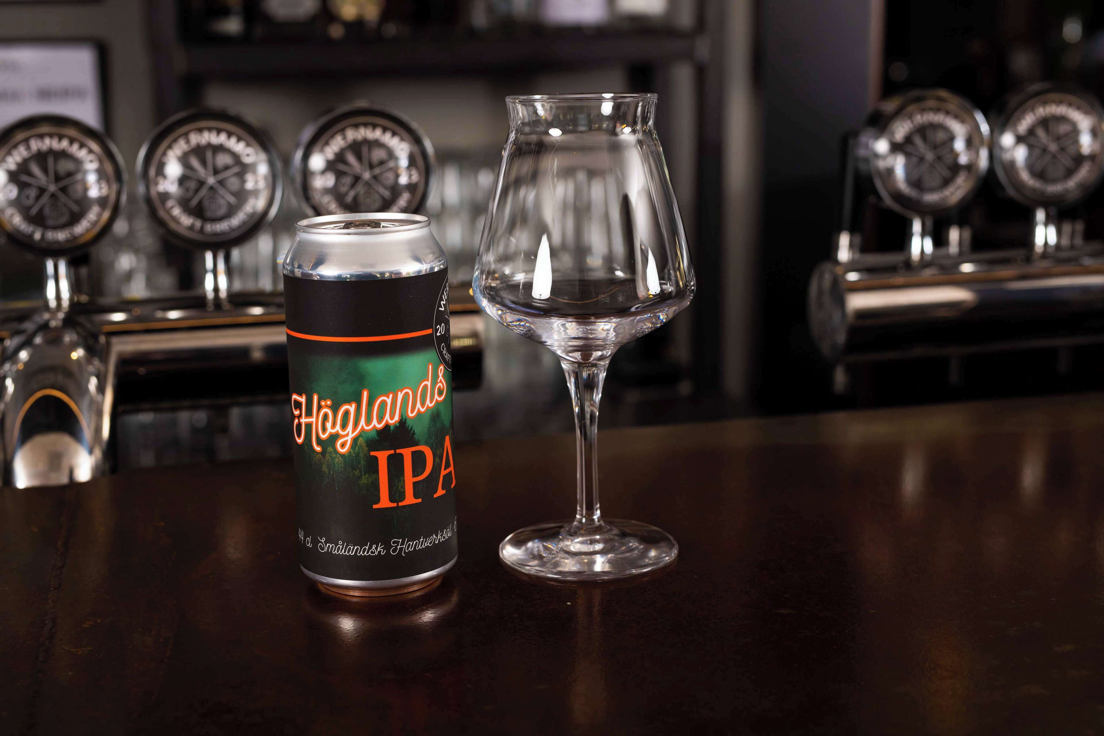 Een blik Höglands IPA en een leeg glas op een bargedeelte.